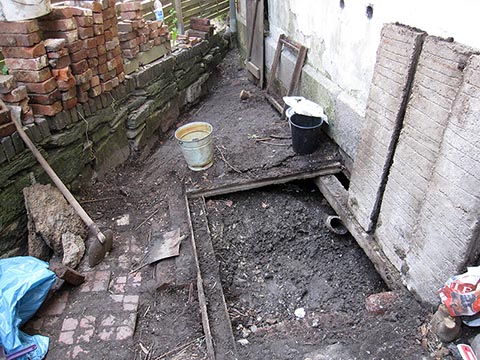 Под бетонными плитами была обнаружена засыпанная отхожая яма.