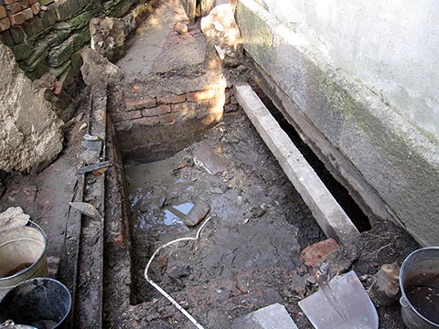 Чистка выгребной ямы киркой и лопатой, откачивание воды.