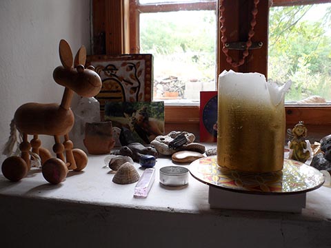 Innenraum des Hauses von István (Istvan Sky) Napfényszentély in Szentbékkállá, Ungarn. Kerze am Fenster. Holzpferd.