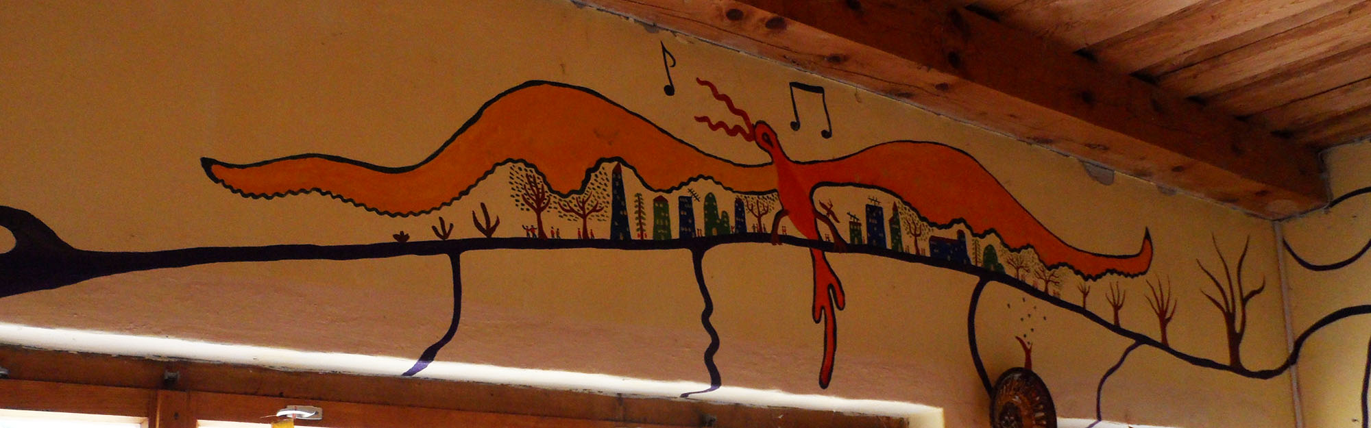 Haus von Istvan Sky (István Sky), Napfényszentély in Ungarn, in Szentbékkállá. Wandmalerei in der Küche. Ein surrealistischer orangefarbener Vogel breitet seine riesigen Flügel über der Stadt aus.