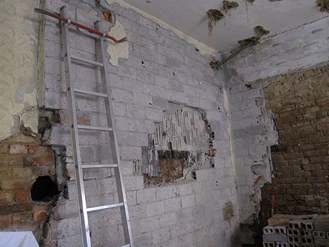 Перед сырой стеной сначала поставили  ещё одну стену в четверть пустотелого кирпича и прикрыли рубероидным листом.