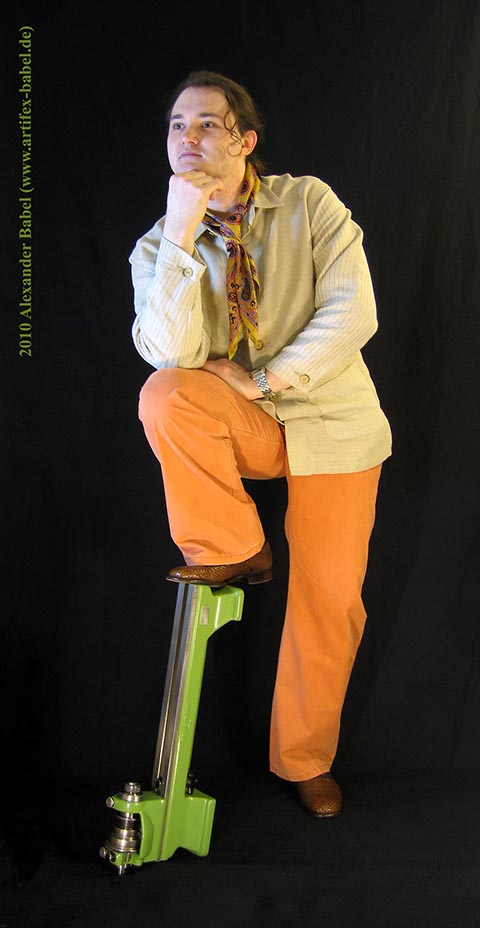 Alexander Babel in Großaufnahme, Ganzkörper, im Profil. Das angewinkelte Bein steht auf der Drehmaschine Schaublin 70.