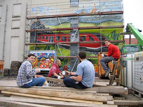 Kurze Pause der Teilnehmer des Projekts „Graffiti Workshop 2004“ vor der Rückwand des InterCityHotel Erfurt, die zu den Bahngleisen zeigt.