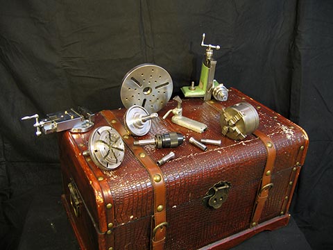 Zubehör für Schaublin 70: Vier- und Sechskantschraubfutter, W12-Spannzangen in verschiedenen Größen, Schraubstock, Spannfutter, Stützstock, Planscheibe.