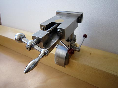 Precision parallel toolmaker's vise with custom mounting design, rotated longitudinally. Full 360° rotation possible.