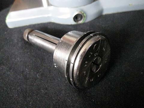 Prata Typ 11 pinion leaf polishing machine. Spindle adjustment bolt with carbide supports featuring triangular notches for the pinion.